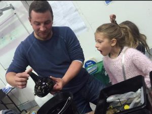 A diver shows a glass onion bottle to a young girl as part ofrooswijk engagement and training