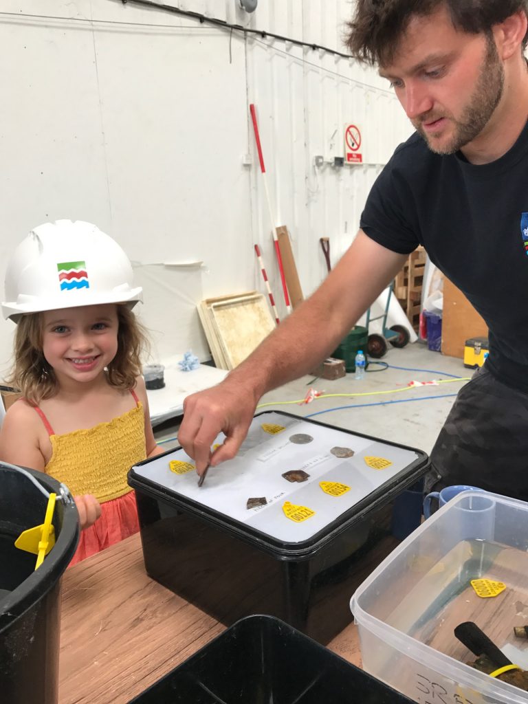 a diver shows finds to a young girl as part of therooswijk engagement and training