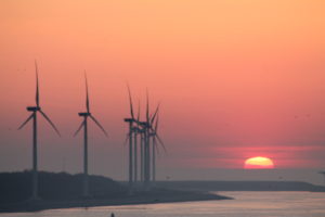 a sunset image of several wind turbines in the distance demonstrating MSDS Marine work in offshore wind archaeology