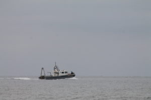 An image of a boat in the distance on the ocean