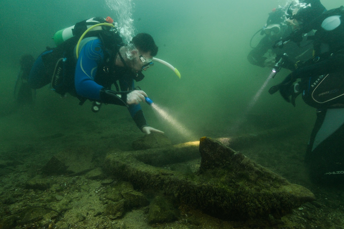 two divers investigate a portion of shipwreck underwater using torches. this was part of the Y heritage Make a splash project funded by the national lottery heritage fund and taught by Go Dive, the Nautical archaeology society and MSDS marine.