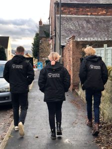 Three MSDS Marine team members walk down the street facing away from the photographer. All three are wearing MSDS Marine coats.